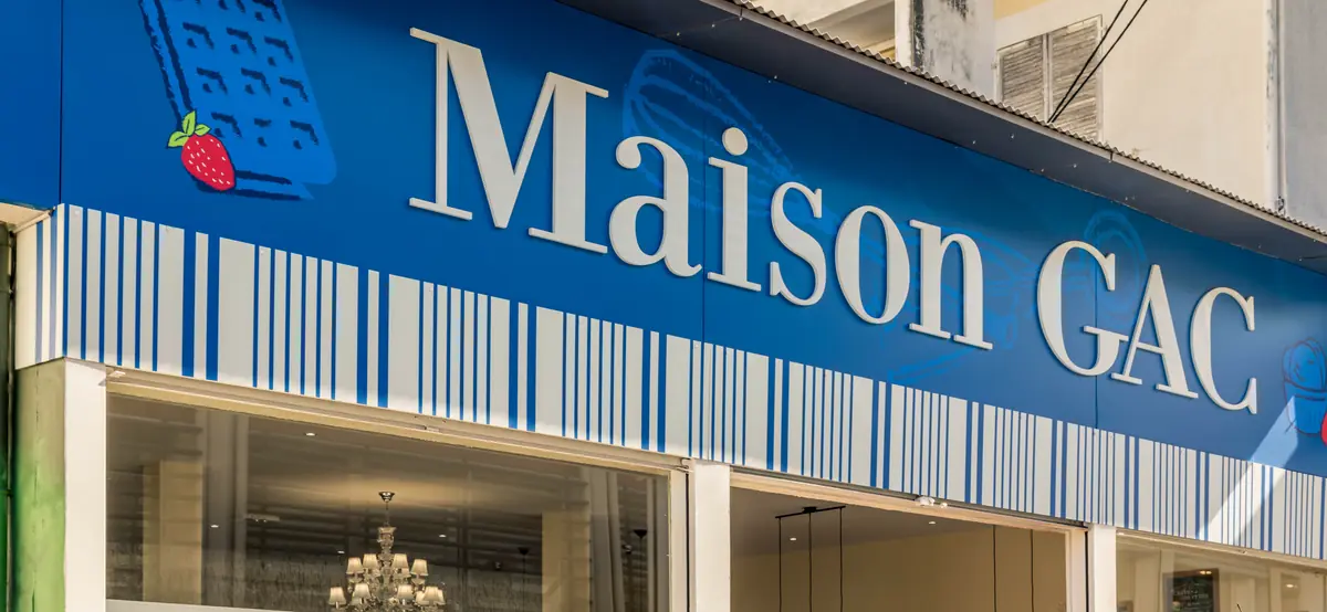 La façade : bandeau bleu, lettrage Maison GAC et frise rayée bleu et blanc
